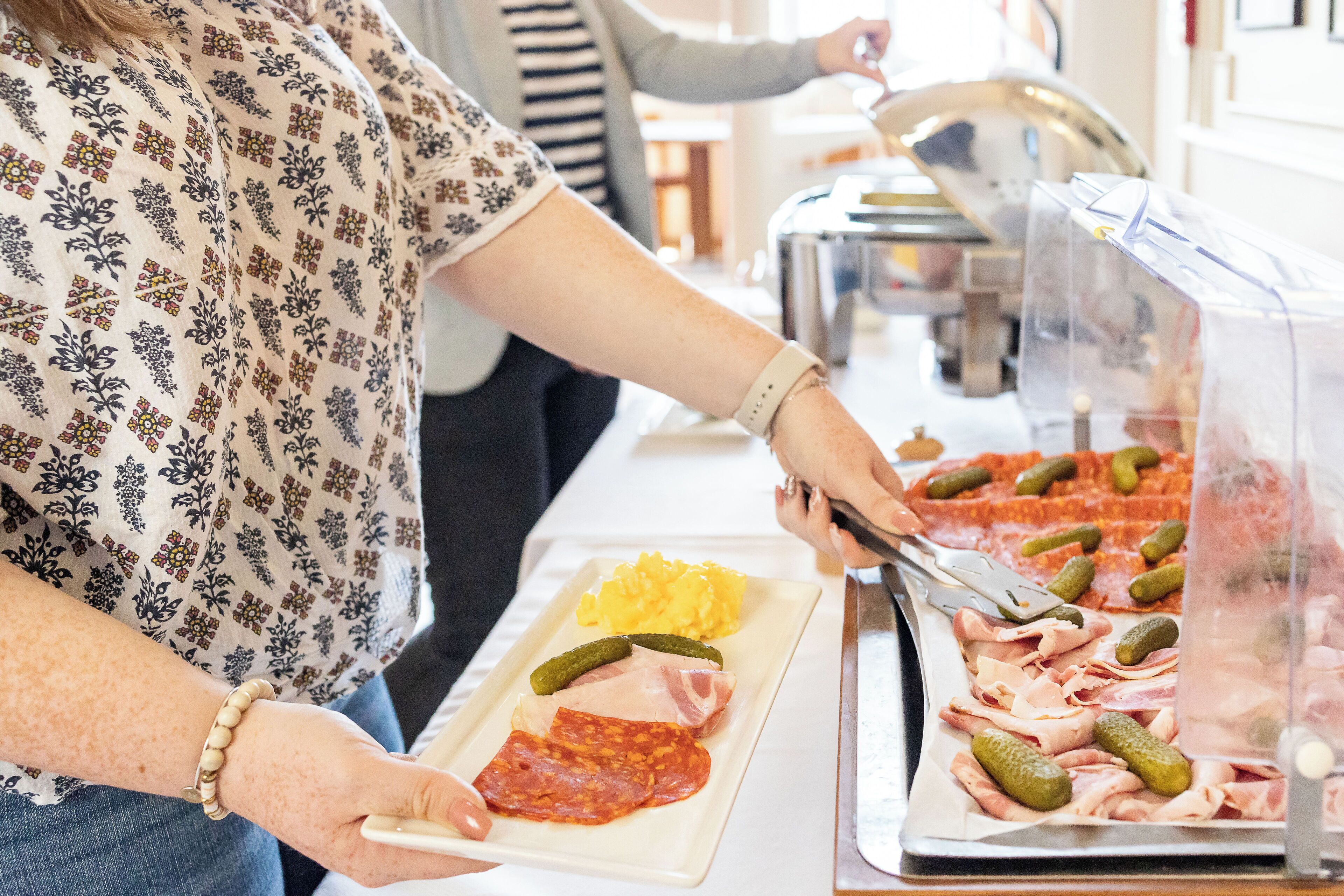 A buffet with various meats and pickles.