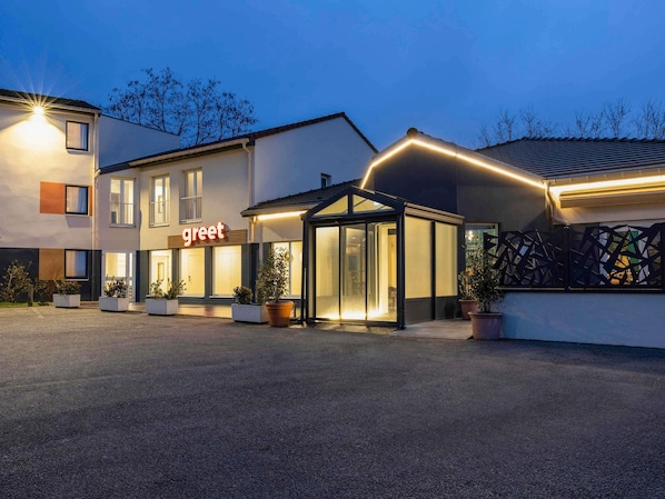 A modern hotel with a 'greet' sign, a covered entrance, and potted plants. - Greet Hotel Nancy Sud (Houdemont)