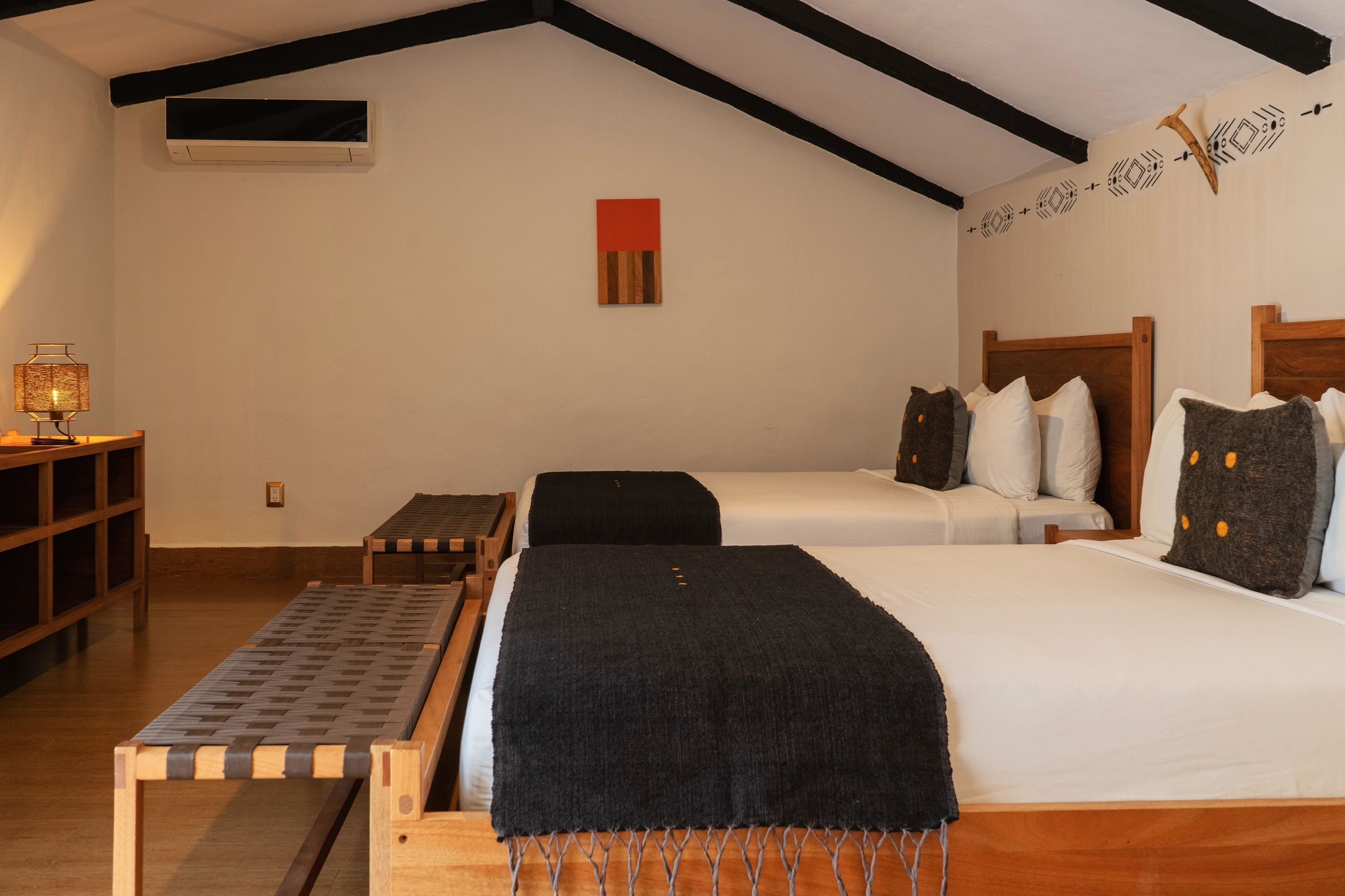 Ein Zimmer mit zwei Betten, einem kleinen Tisch und einem Regal.