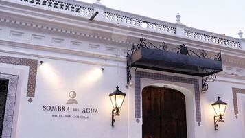 Fachada exterior del Hotel Sombra del Agua, con diseño tradicional, detalles de metal ornamentado y una gran puerta de madera.