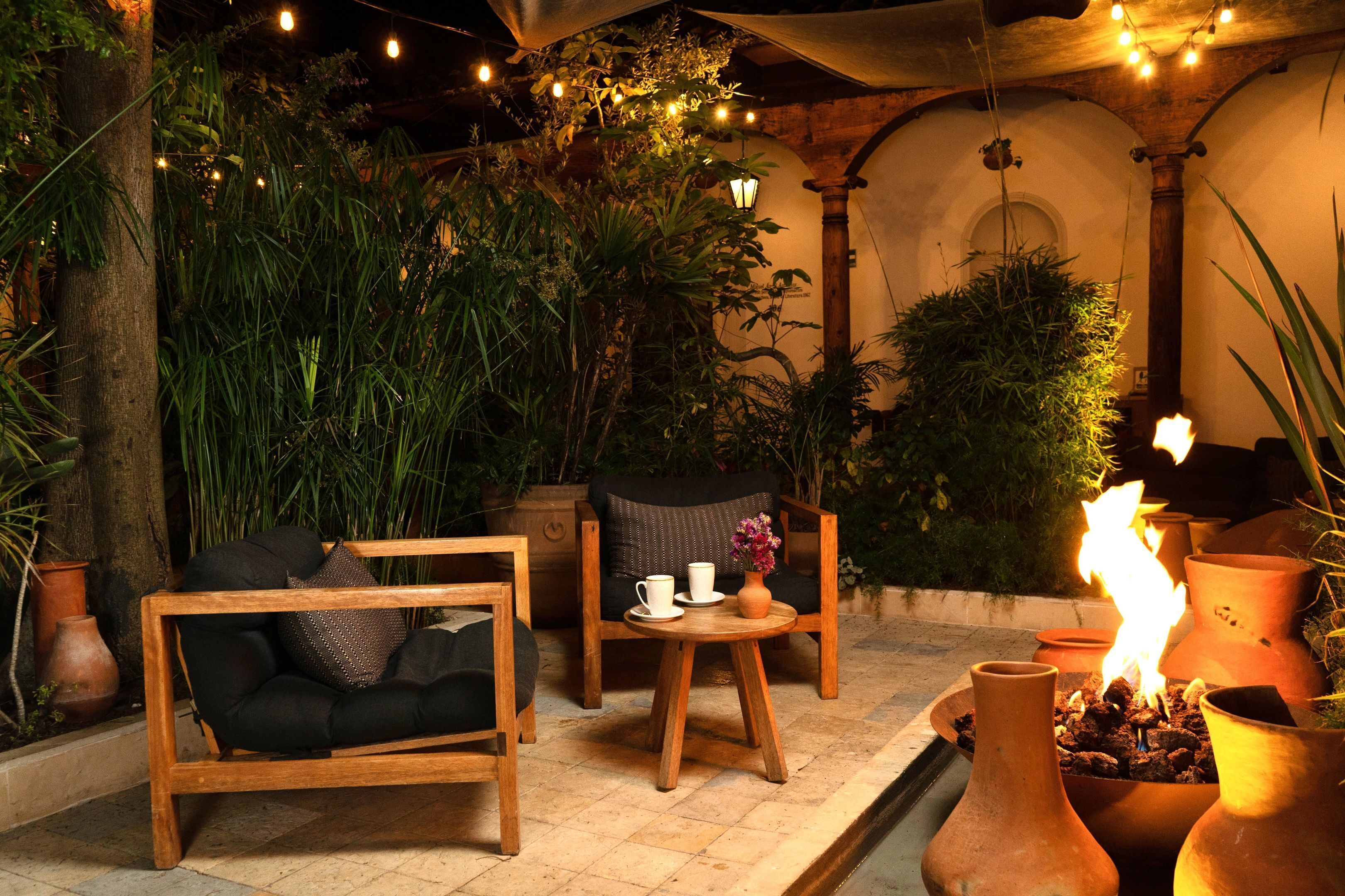 Un área de estar al aire libre acogedora, con muebles de madera y macetas de terracota.