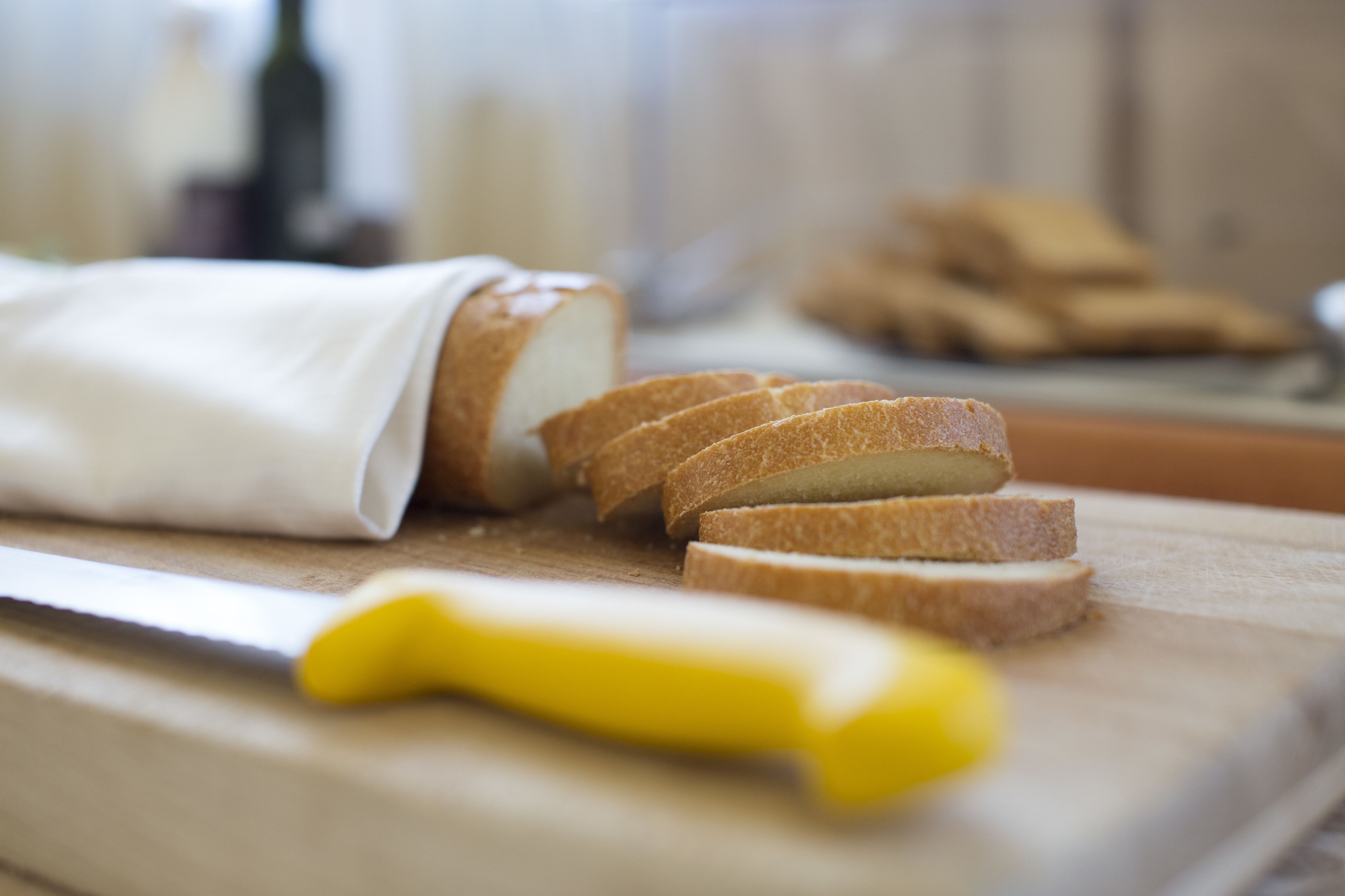 Leikattu leipäviipale leikkuulaudalla, vieressä veitsi.