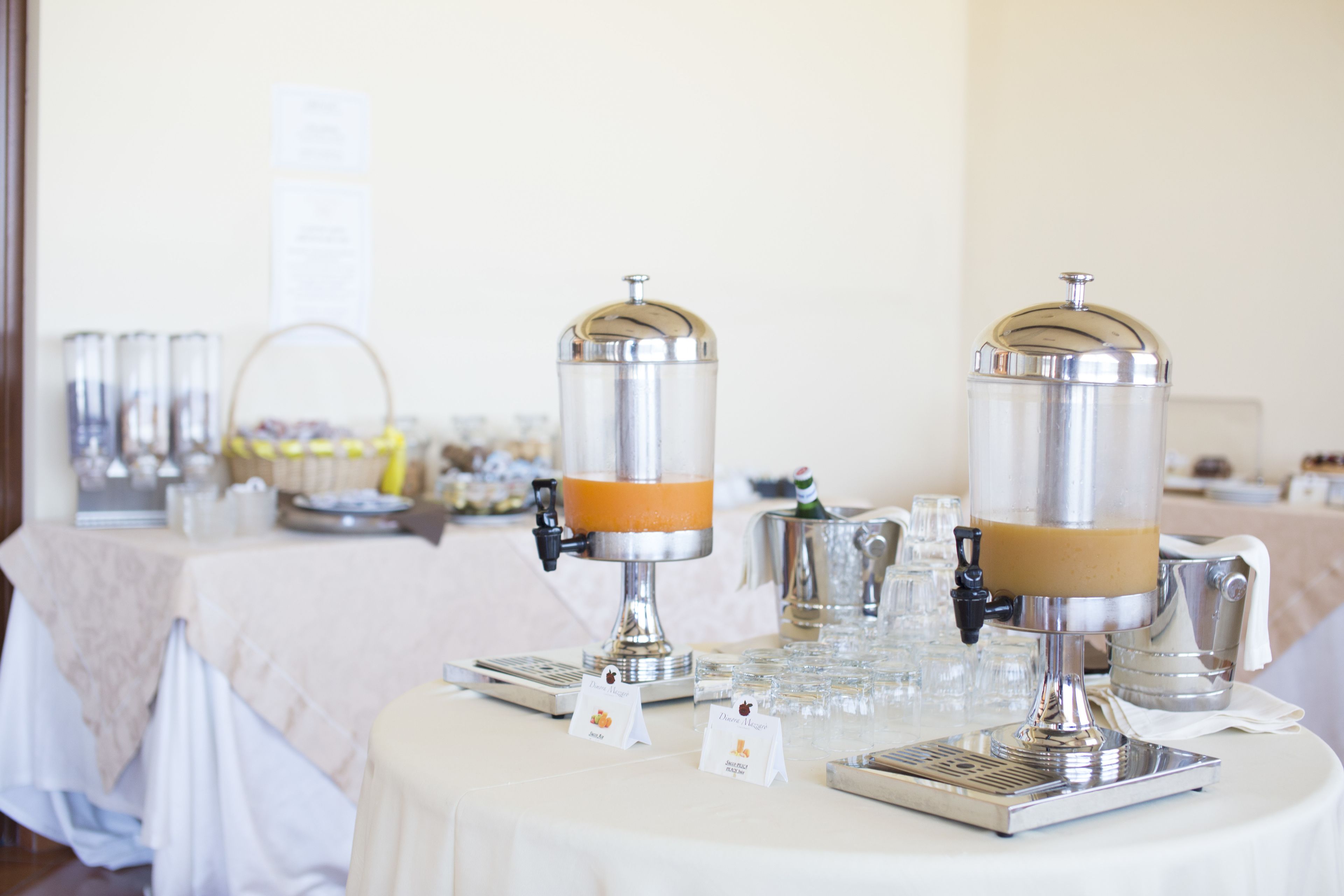 A buffet setup with two beverage dispensers, a variety of food items, and a clean, organized table.