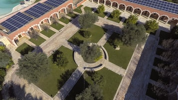 Guests can enjoy a serene courtyard with a central garden, surrounded by arches and a covered walkway.