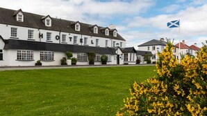 A white building with multiple windows and a flag. - Kings Arms Hotel (Kyleakin)