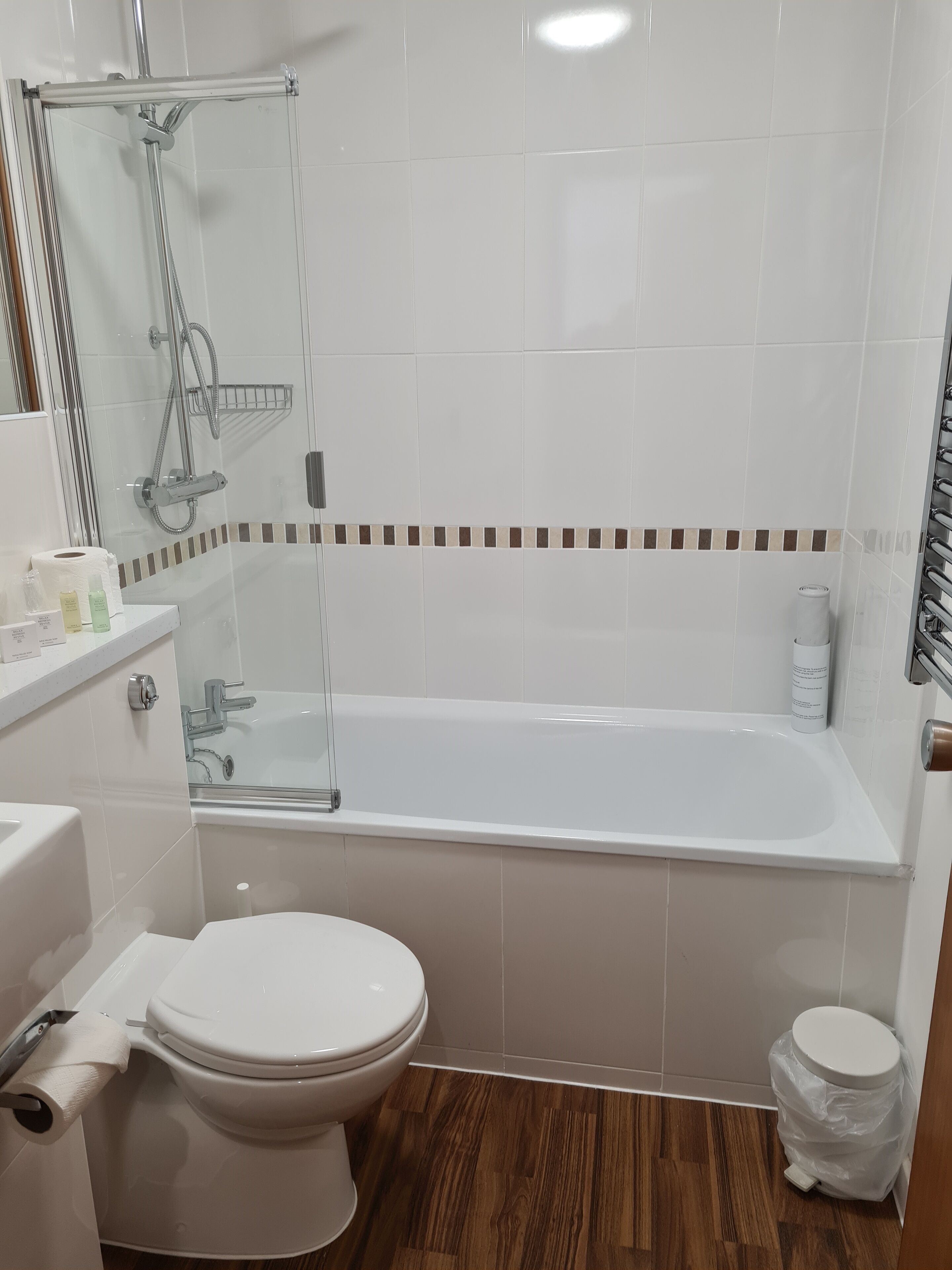 A modern bathroom with a bathtub, toilet, and shower area.