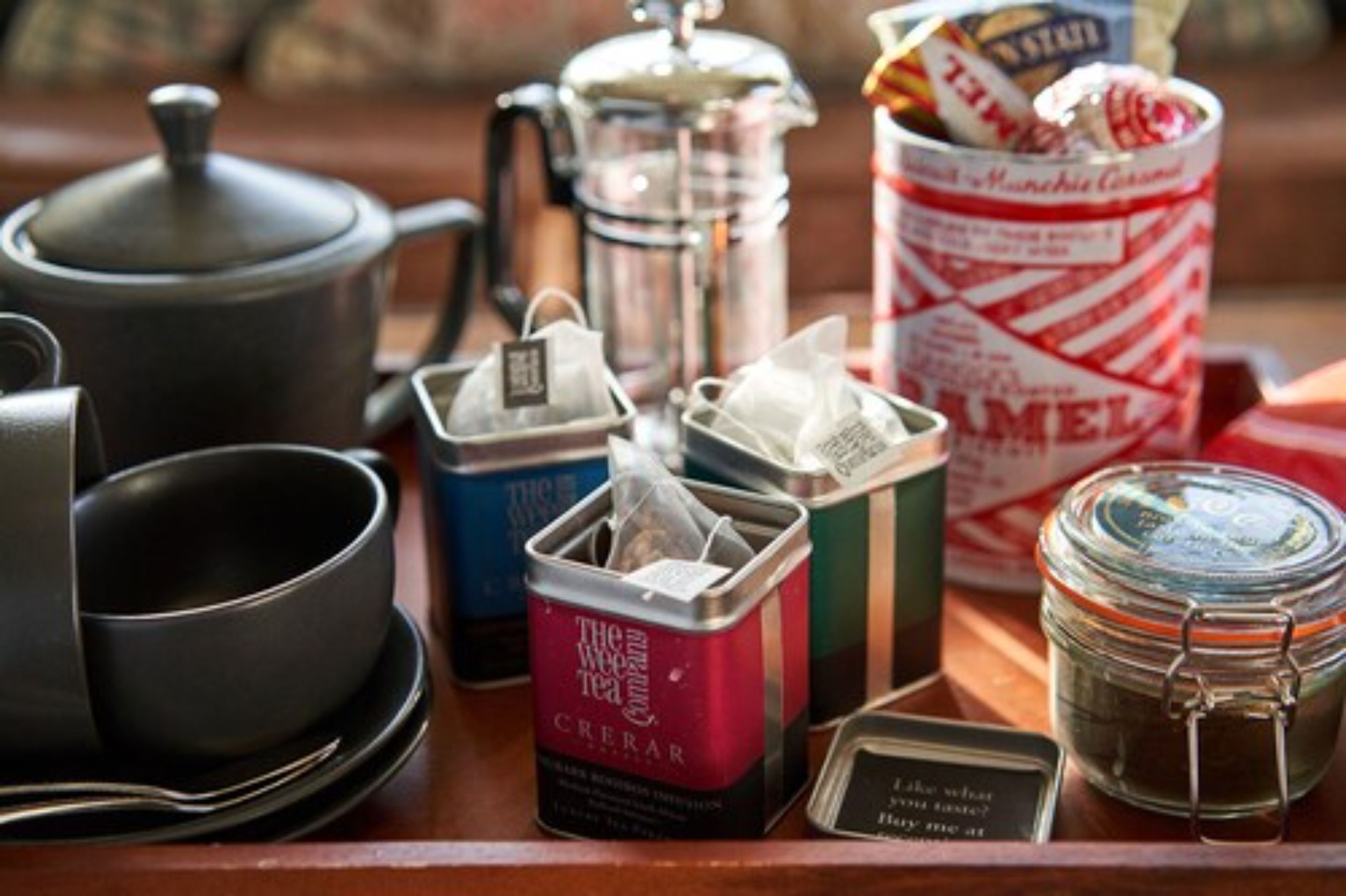 A tea set with a teapot, cups, and a sugar bowl on a wooden table.