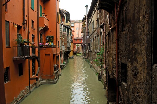 Un stretto canale fiancheggiato da edifici con balconi e fioriere.