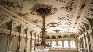 An ornate interior with a large chandelier, arched windows, and detailed ceiling artwork. - Tisza Hotel (Szeged)
