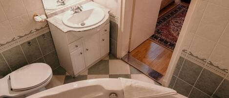 A bathroom with a large bathtub, a sink, and a toilet.