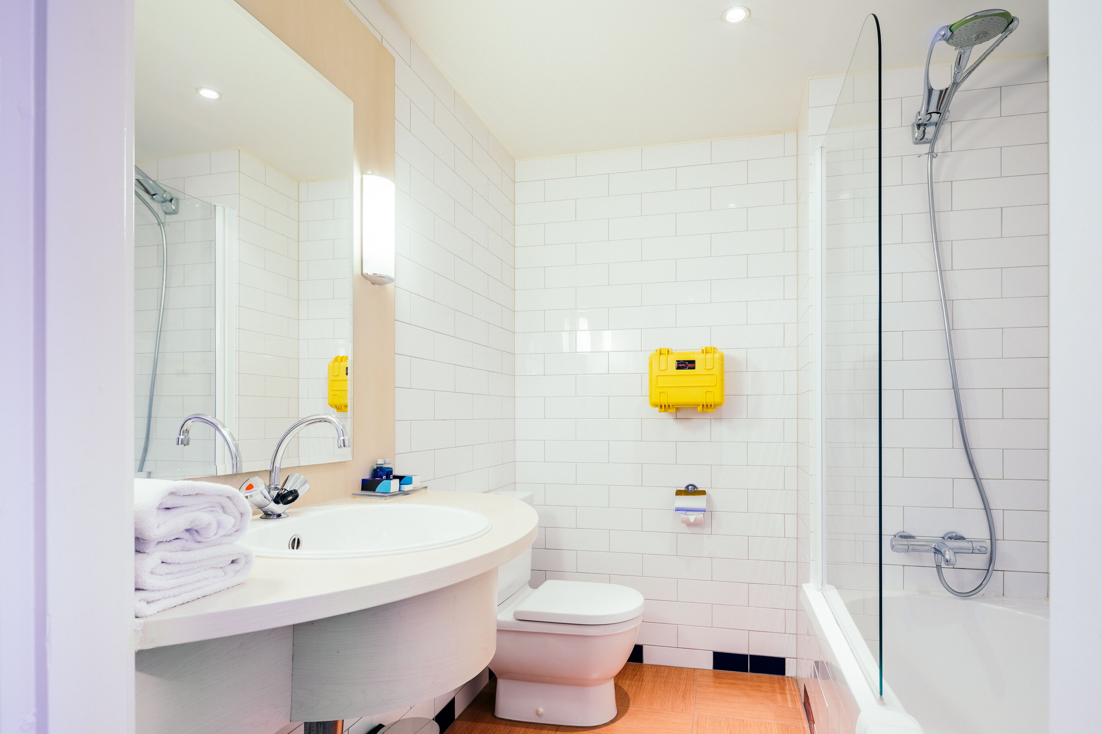 A bathroom with a white sink, toilet, and glass-enclosed shower.