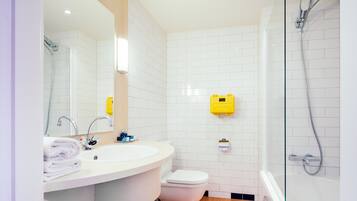 A bathroom with a white sink, toilet, and glass-enclosed shower.