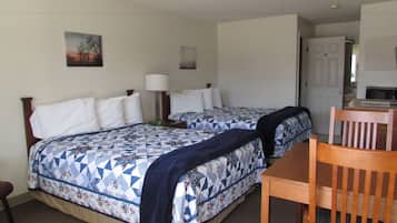 Habitación de hotel con dos camas, un escritorio y una silla.