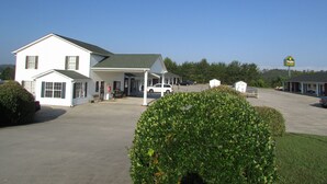 A two-story motel with a covered parking area and a sign for 'Douglas Inn & Suites'. - Douglas Inn & Suites (Blue Ridge)