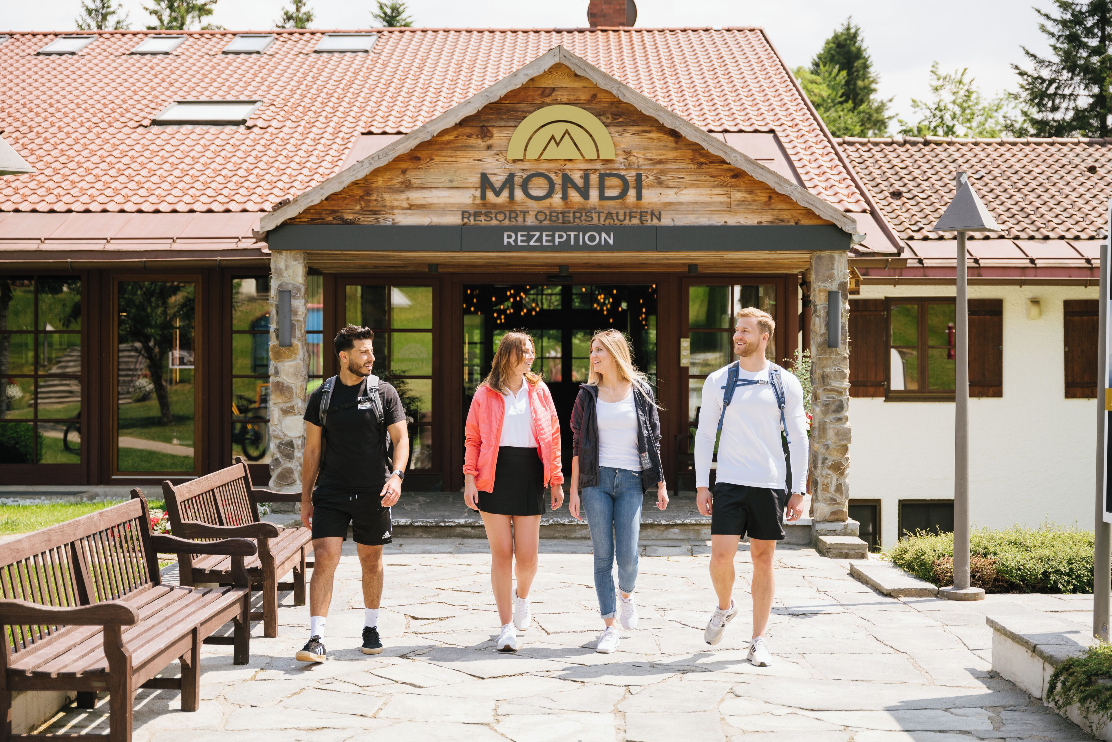 A wooden building with a sign reading "MONDI RESORT OBERSTAUFEN RECEPTION".