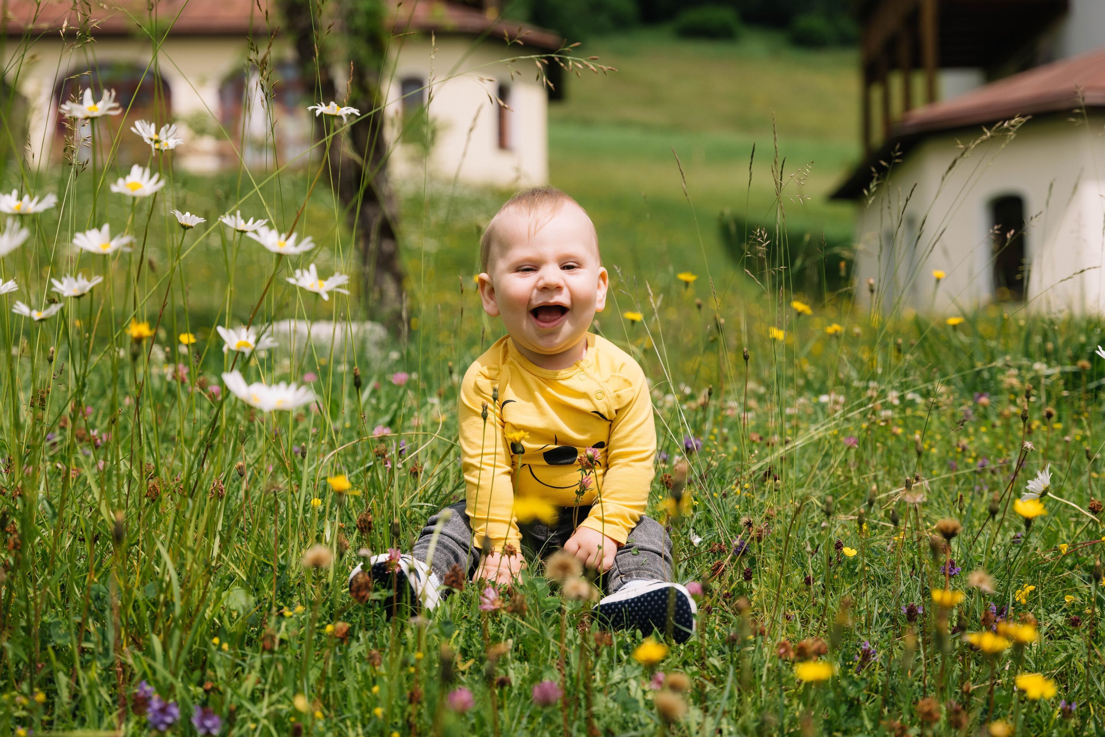 A child sitting in a field of flowers.