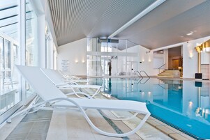 Una piscina cubierta, tumbonas