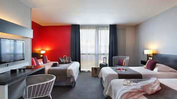 Une chambre d’hôtel avec deux lits, un bureau, une télévision et une vue sur la ville.