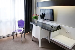 Relax in a stylish room with a sleek desk, flat-screen TV, and comfortable chair.