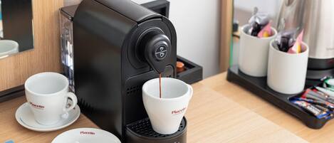 Una máquina de café sirviendo café en dos tazas sobre una mesa de madera.