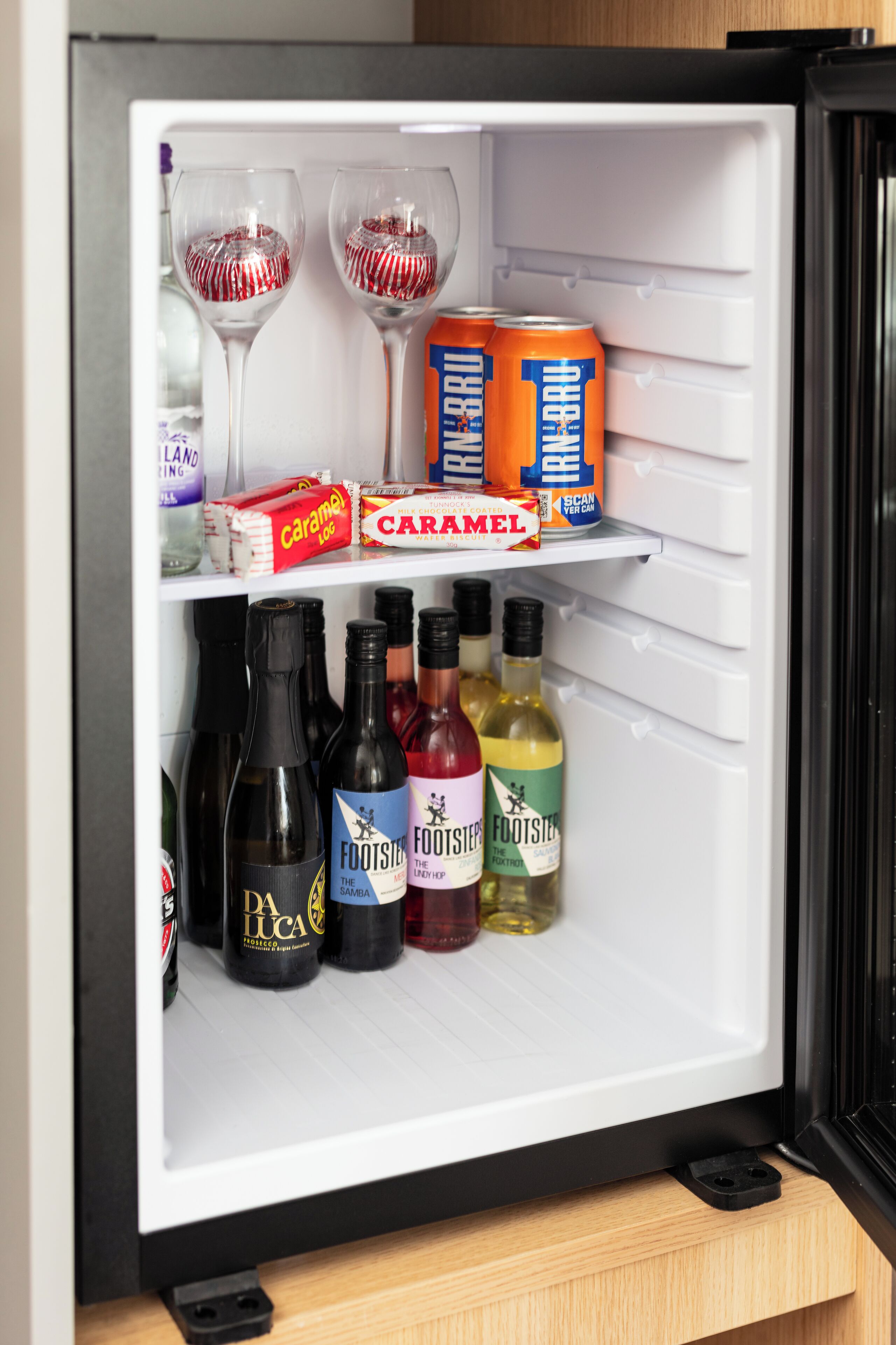 A refrigerator stocked with beverages and snacks.