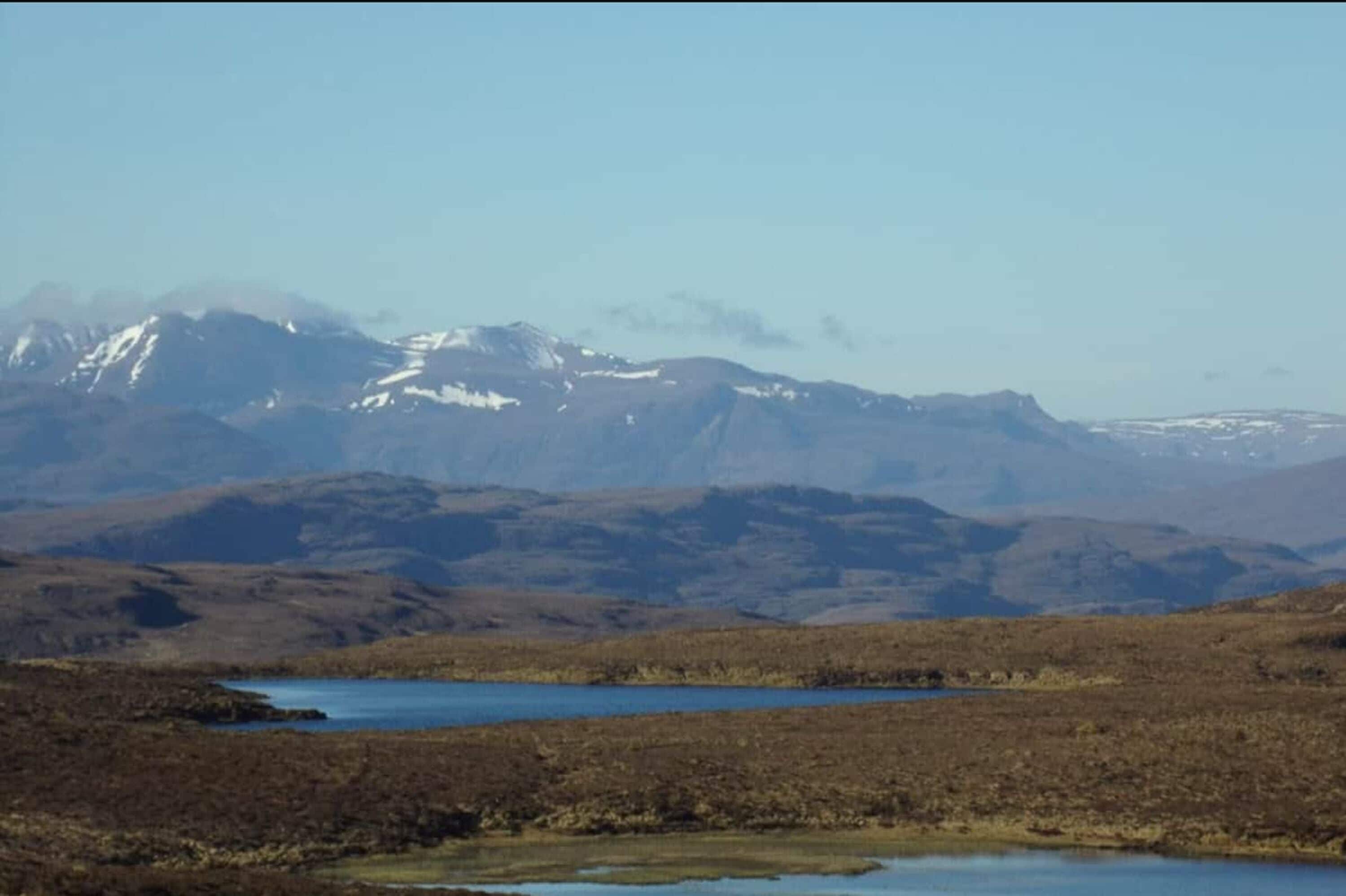 Un paisaje montañoso con un lago y vegetación escasa.