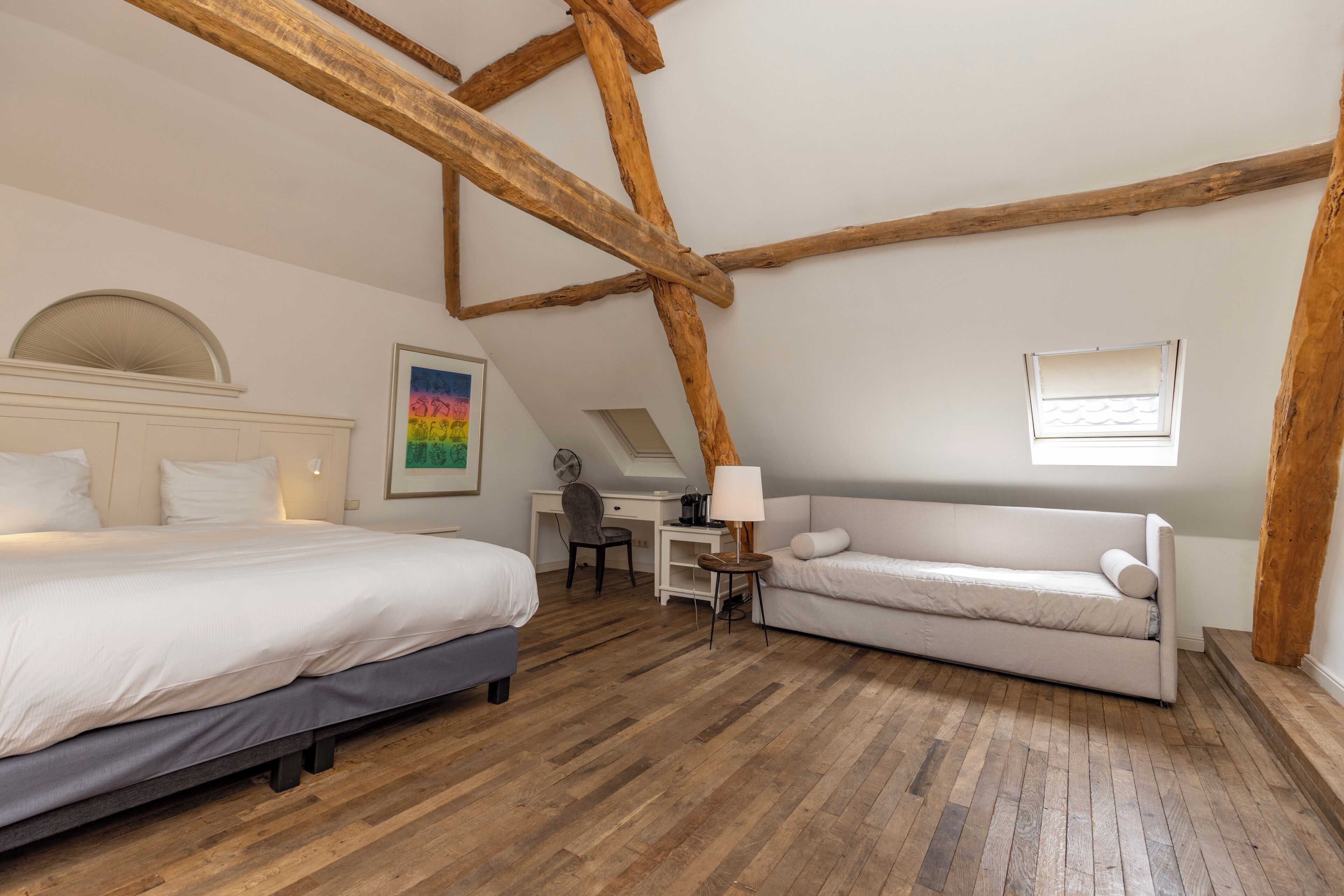 Quarto com cama, sofá, escrivaninha e cadeira.