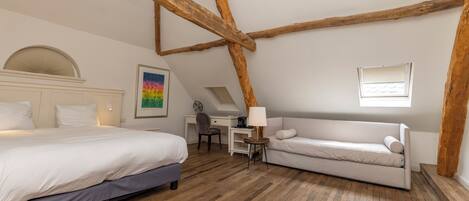 Quarto com cama, sofá, escrivaninha e cadeira.