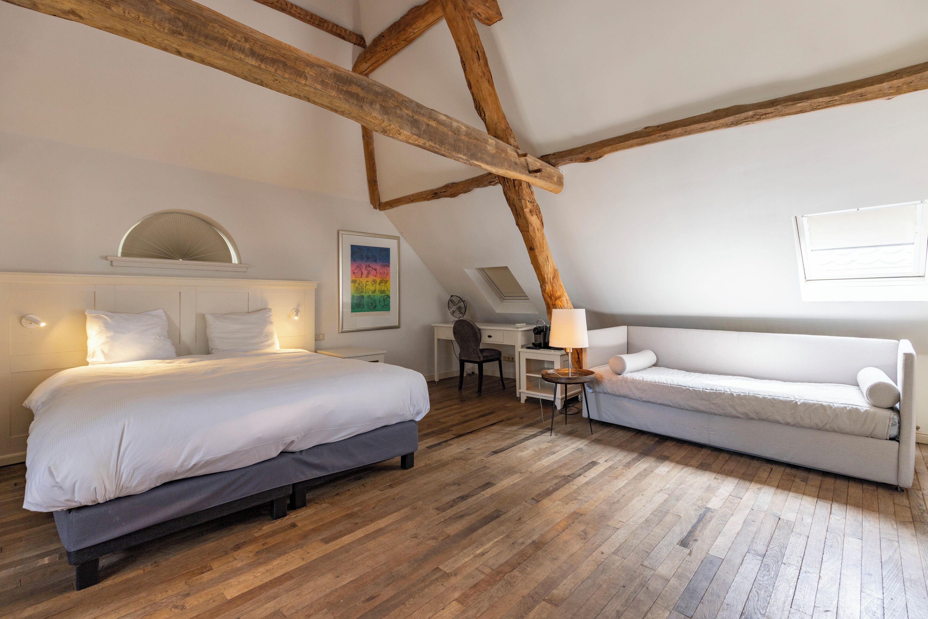 Une chambre avec un plafond en bois, un lit, un canapé, un bureau et une chaise.
