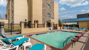 A hotel with a swimming pool, lounge chairs, and a covered area. - Comfort Suites Baytown I - 10 (Baytown)