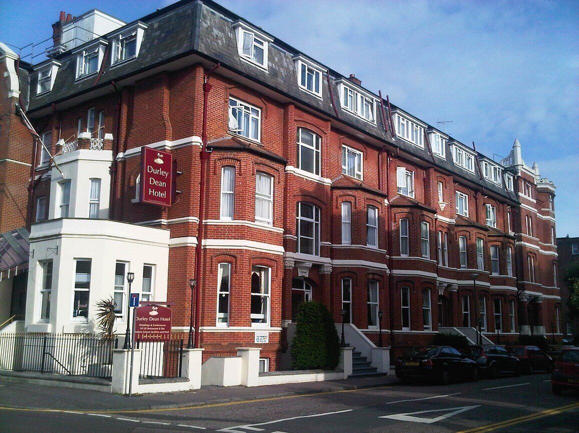Un bâtiment en briques rouges sur lequel on peut lire une enseigne indiquant le « Durley Dean Hotel ».