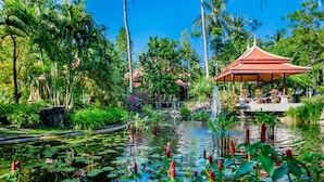 A serene garden with a pond, lush greenery, and a traditional pavilion. - Duangjitt Resort, Phuket (Patong)
