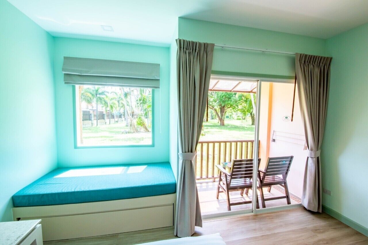 A room with a built-in bench by a window, a sliding glass door leading to an outdoor area with a table and chairs.