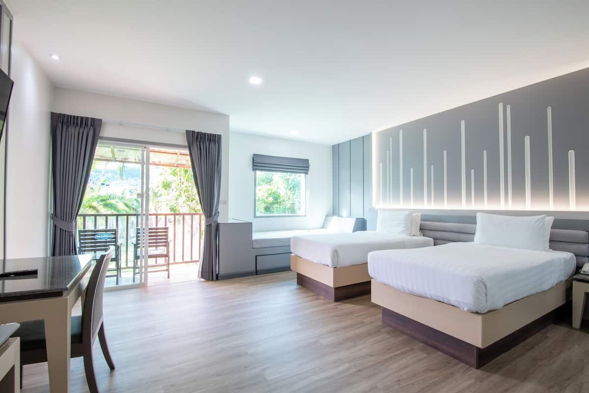 A modern hotel room with a balcony, two beds, a desk, and a dining area.