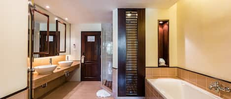 Un baño moderno con dos lavamanos, una bañera grande y un espejo.