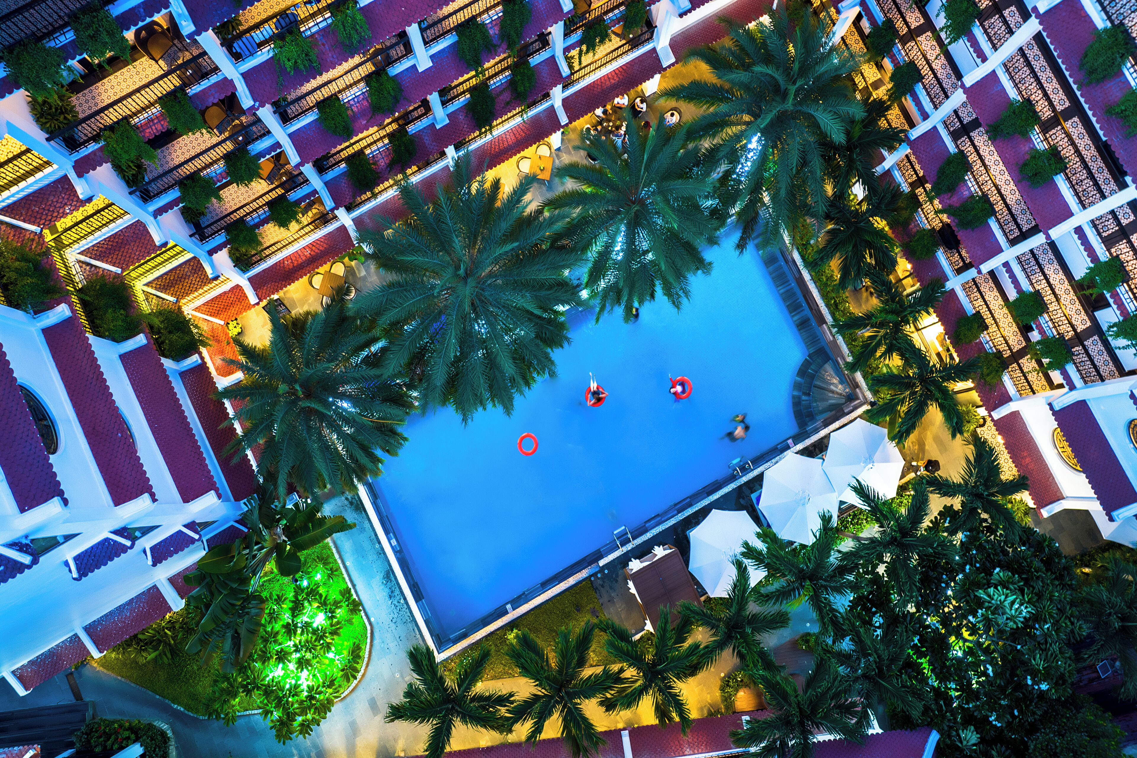 Una piscina al aire libre, sombrillas, sillones reclinables de piscina