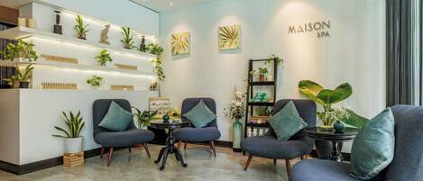 A modern interior with a reception desk, seating area, and a wall displaying 'MAISON SPA'.