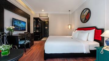 Una habitación de hotel moderna con una cama grande, un escritorio, una silla y un televisor.