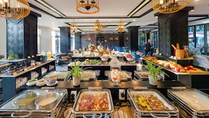 A buffet area with various food stations, including fruits, vegetables, and meats. - Hadana Boutique Resort Hoi An (Da Nang)