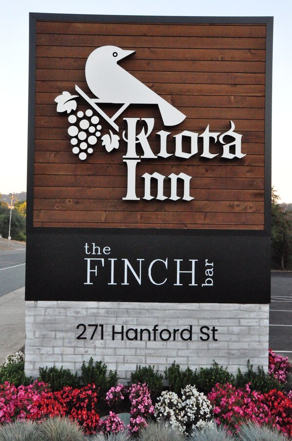 Letrero de 'Riota Inn' con un gráfico de pájaro y uvas, que indica un bar llamado 'The Finch bar' en la calle Hanford, 271.