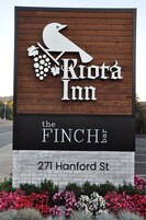 Letrero de 'Riota Inn' con un gráfico de pájaro y uvas, que indica un bar llamado 'The Finch bar' en la calle Hanford, 271.