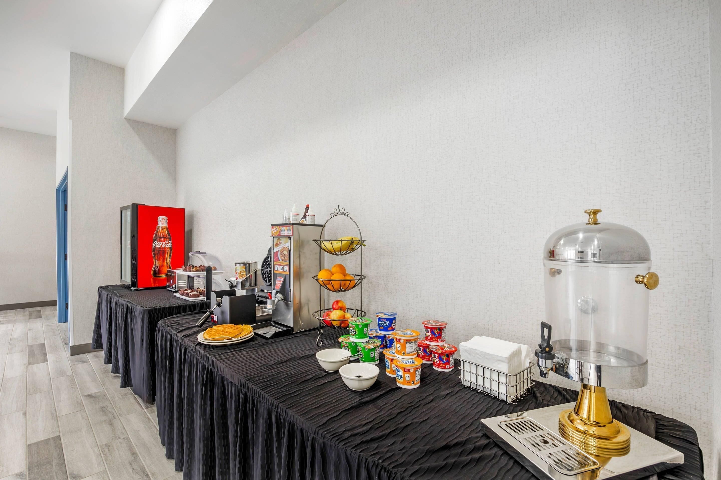 A buffet setup with various food items and a beverage dispenser.