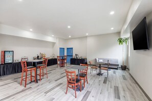A modern conference room with a long table, several chairs, a sofa, a TV, and a plant. - Kiota Inn & Event Center Sutter Creek, an Ascend Collection Hotel (Sutter Creek)