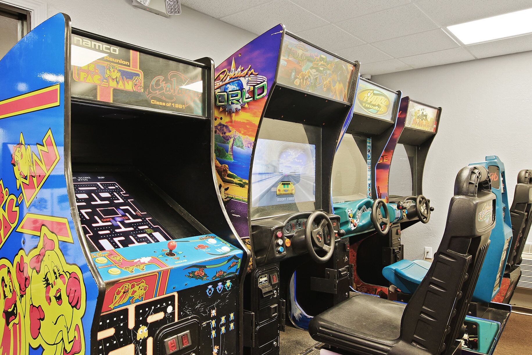 Una fila di cabinati arcade con grafica colorata e comandi.