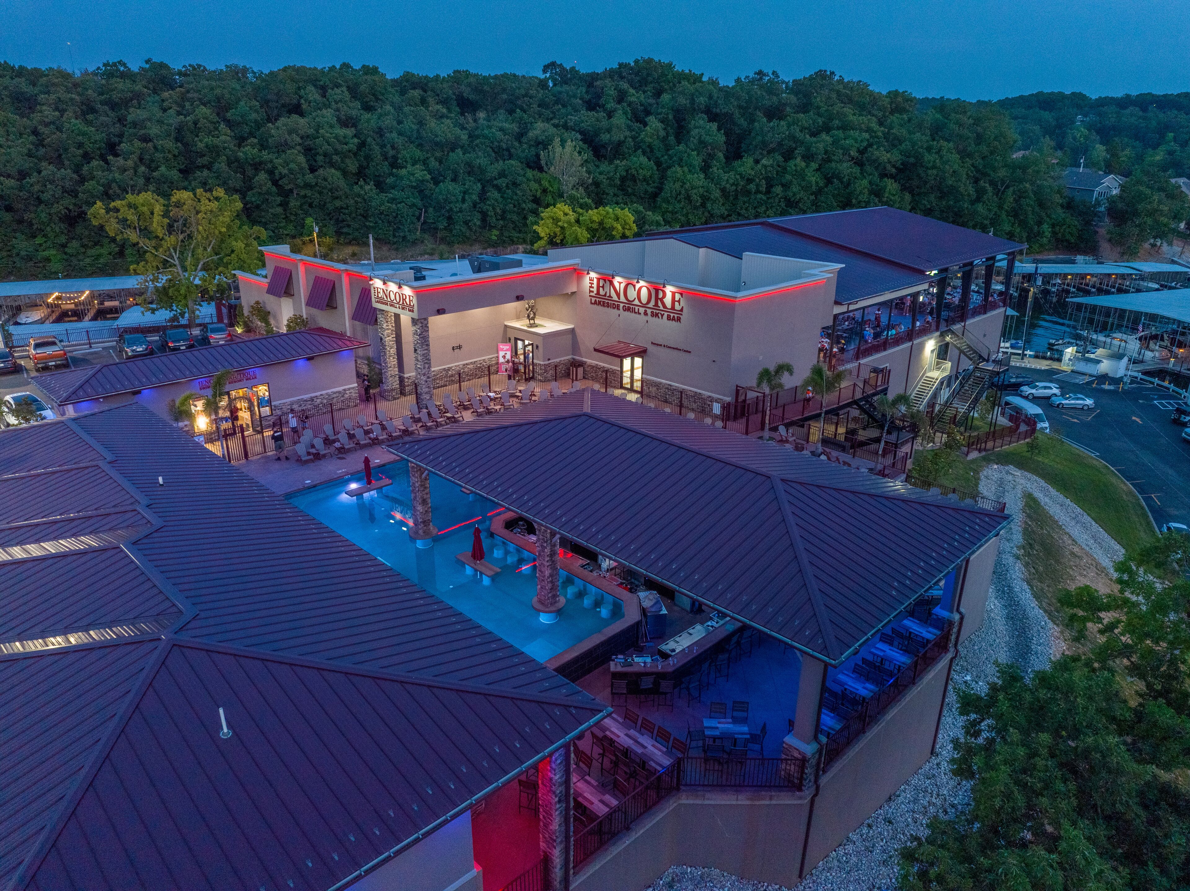 A hotel with a swimming pool, outdoor seating, and a restaurant named "The Encore."