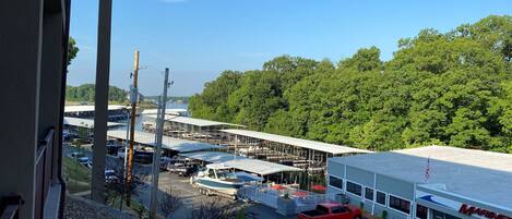 Un puerto deportivo con barcos amarrados, una camioneta roja y un edificio con el rótulo 'MARINE'.