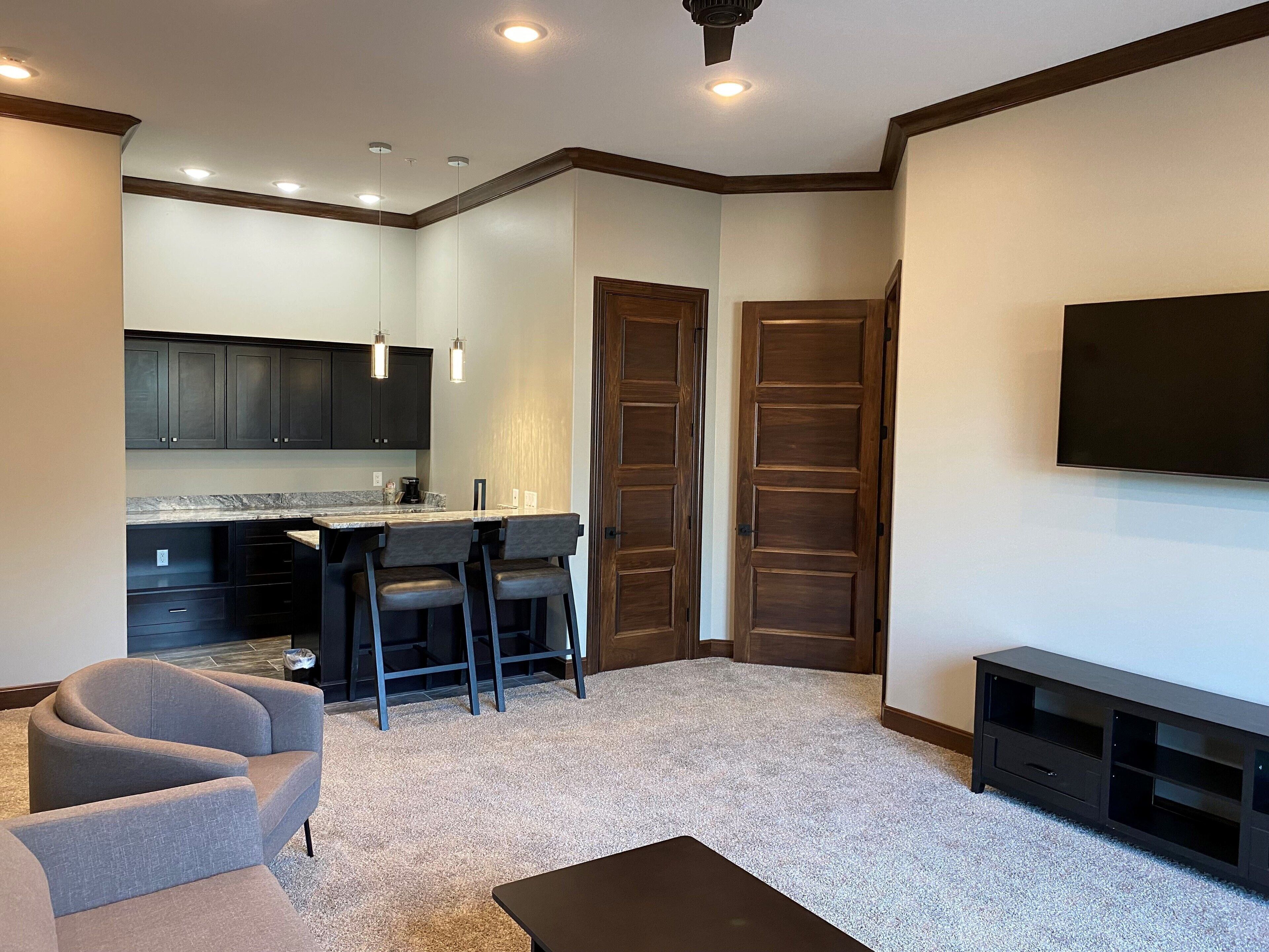 A modern living room with a grey sofa, a coffee table, and a TV mounted on the wall.