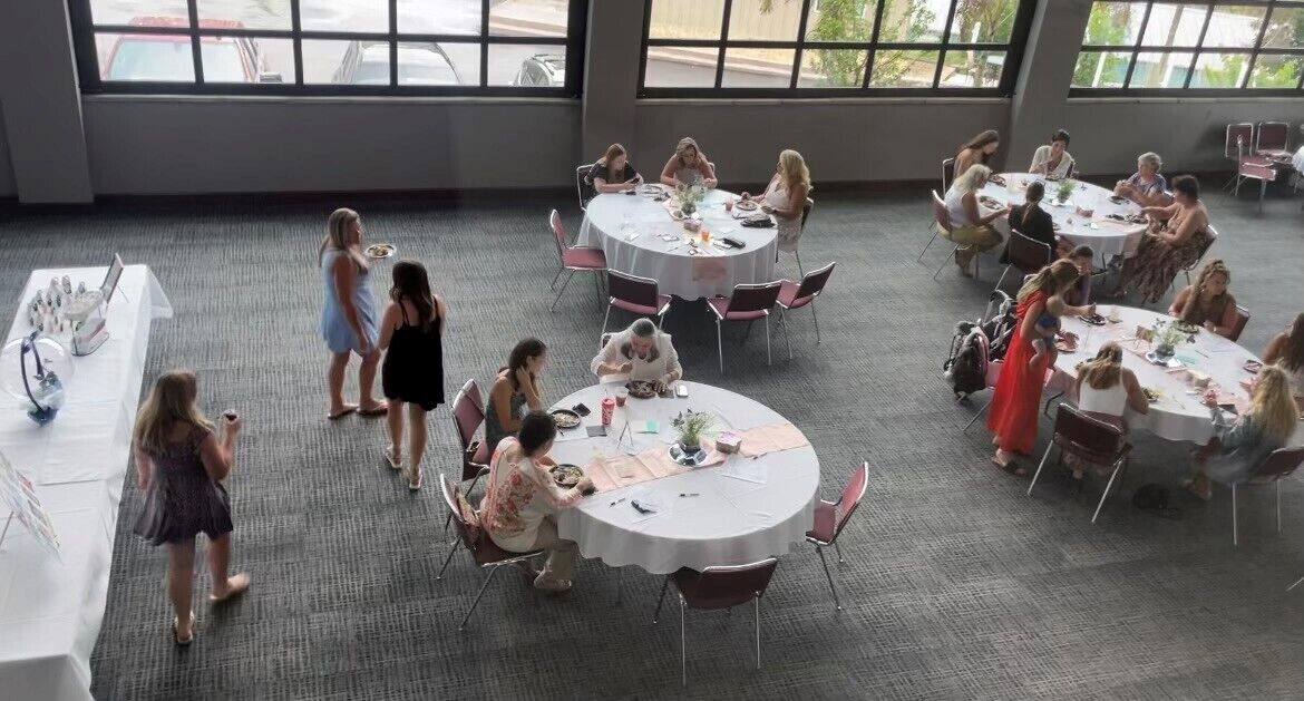 A spacious room with multiple round tables arranged in a circular pattern, allowing for group interactions.