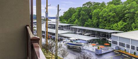 Un puerto deportivo con barcos amarrados, una zona de aparcamiento techada y un edificio de fachada blanca.