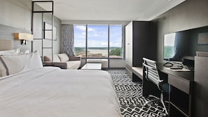 A hotel room with a large bed, a desk with a computer, a TV, and a view of the outdoors. - The Resort at Lake of the Ozarks (Lake Ozark)